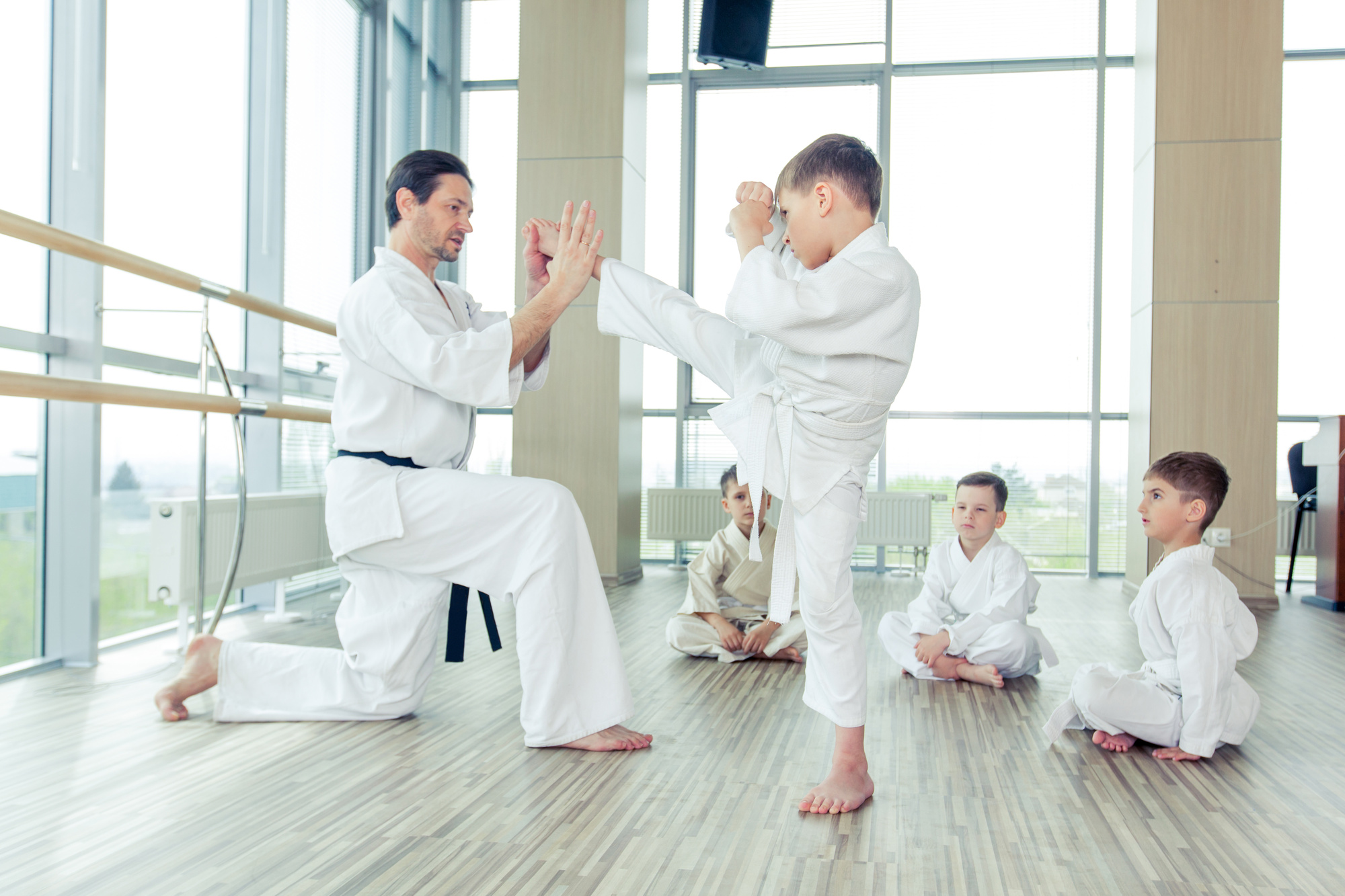 A man and boy in white uniforms practicing karate.