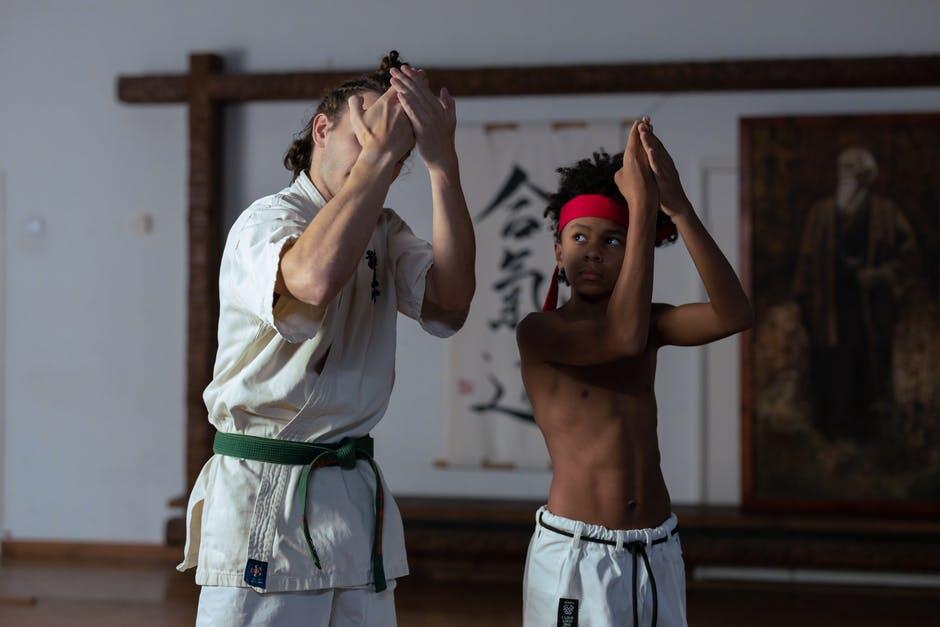 a boy training in the gym with his trainer